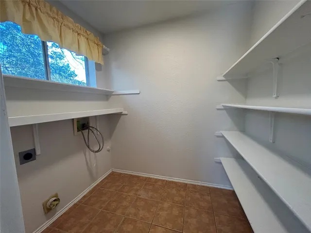 a view of storage and utility room with a window