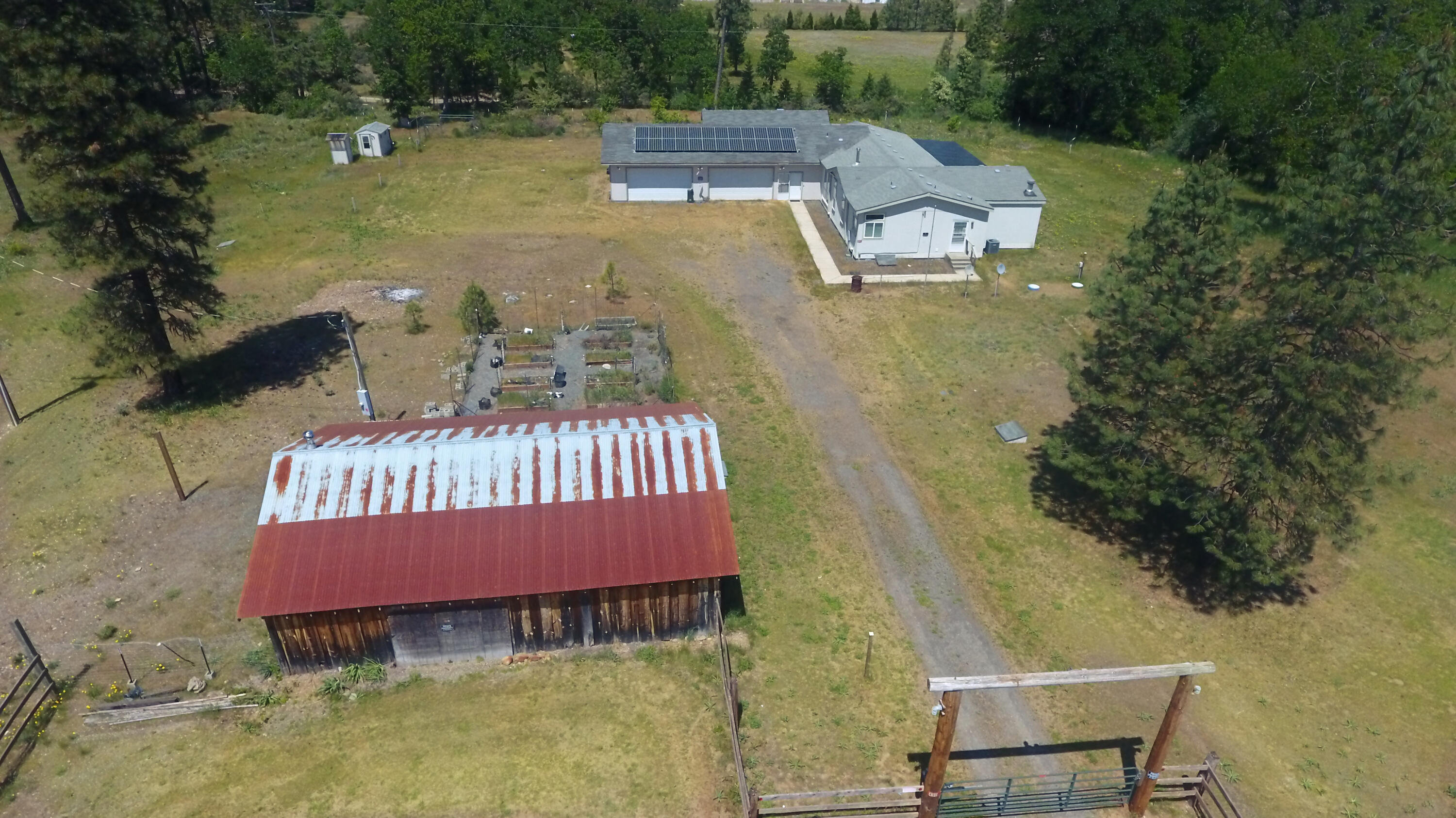 4911 Rockydale Road Cave Junction, OR 97523 - Photo 2 of 25 an aerial view of a house with swimming pool and red chairs