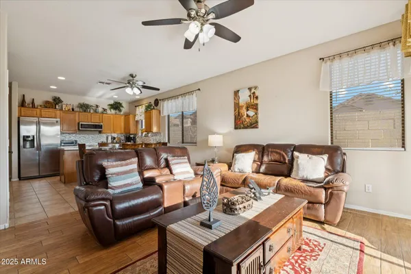a living room with furniture kitchen view and a large window