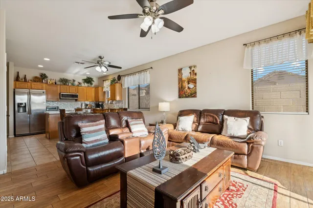 a living room with furniture kitchen view and a large window