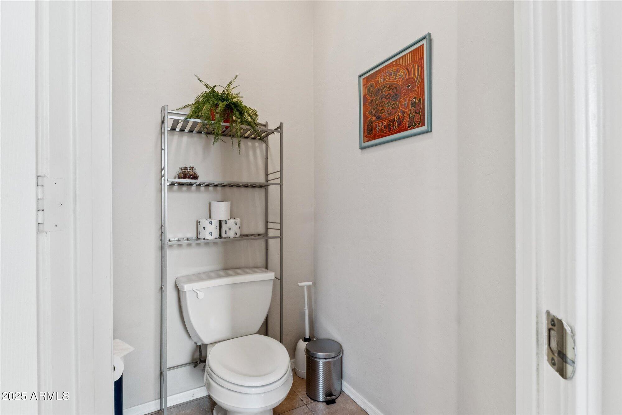 6848 South 27th Street Phoenix, AZ 85042 - Photo 9 of 28 a bathroom with a toilet and a shower curtain