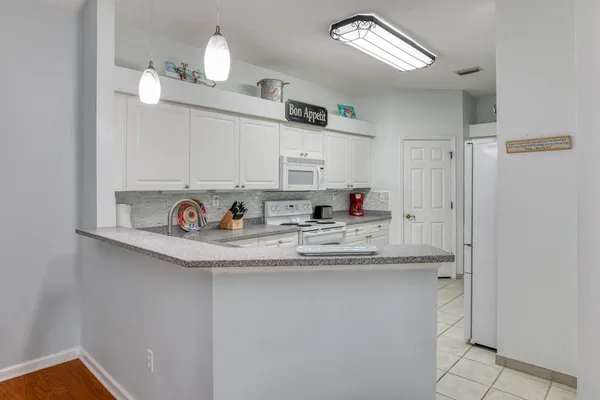 a kitchen with stainless steel appliances granite countertop a sink refrigerator and cabinets