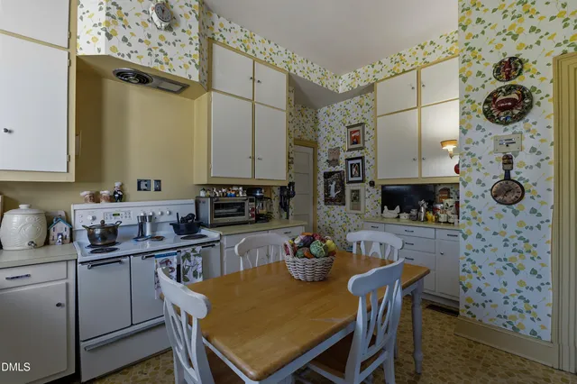 a backyard of a house with large trees and outdoor seating