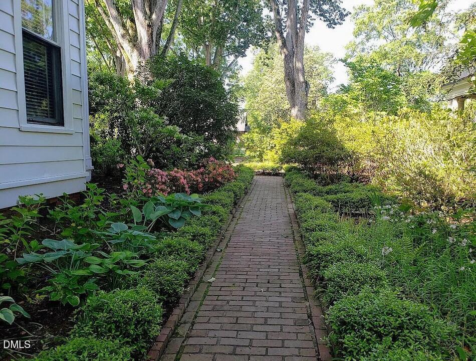 900 Nash Street North Wilson, NC 27893 - Photo 73 of 99 a view of a pathway with flower plants and wooden fence