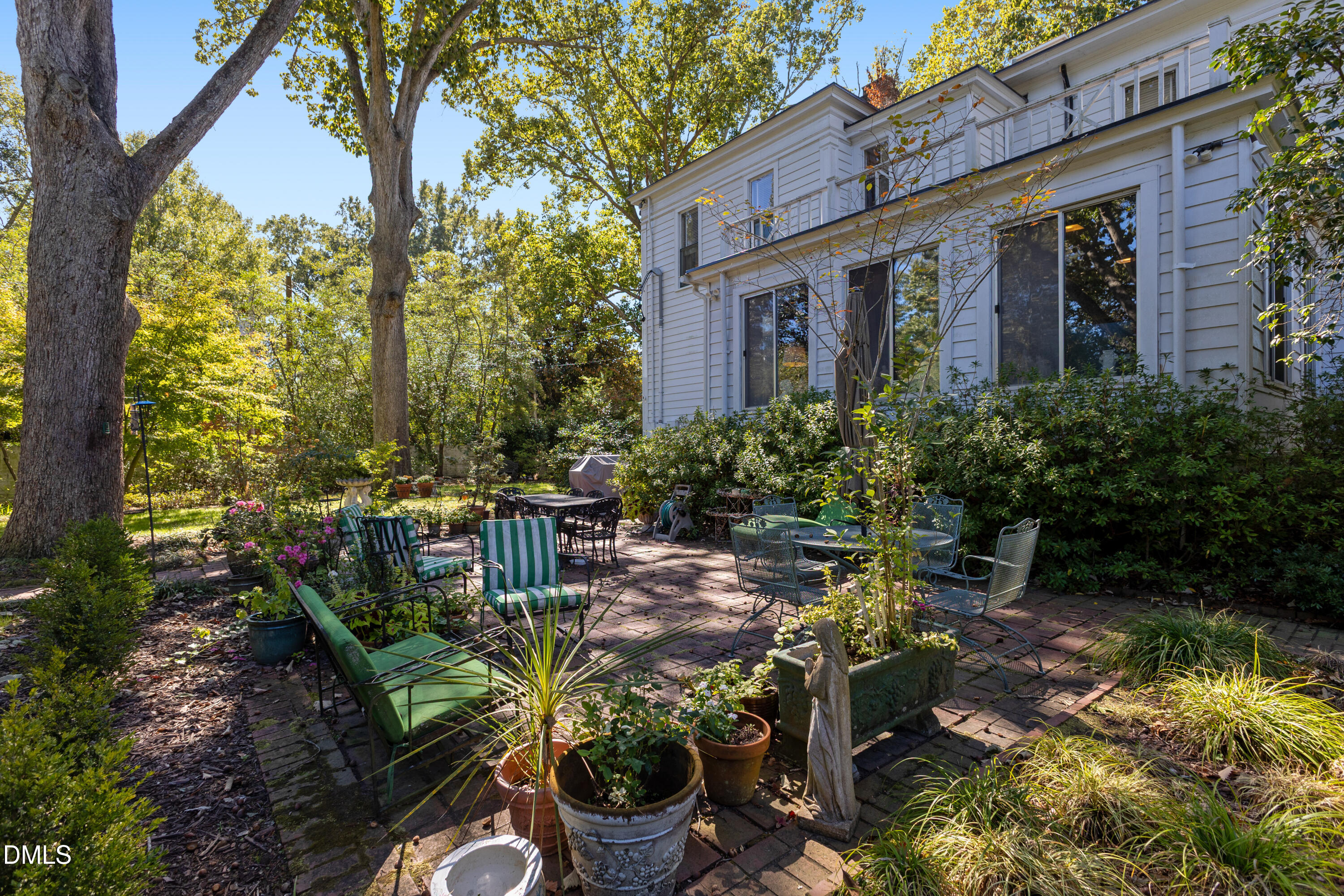 900 Nash Street North Wilson, NC 27893 - Photo 77 of 99 a view of a patio with table and chairs potted plants and large tree