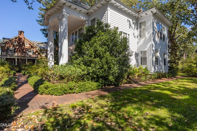 a living room with furniture a chandelier and a bookshelf