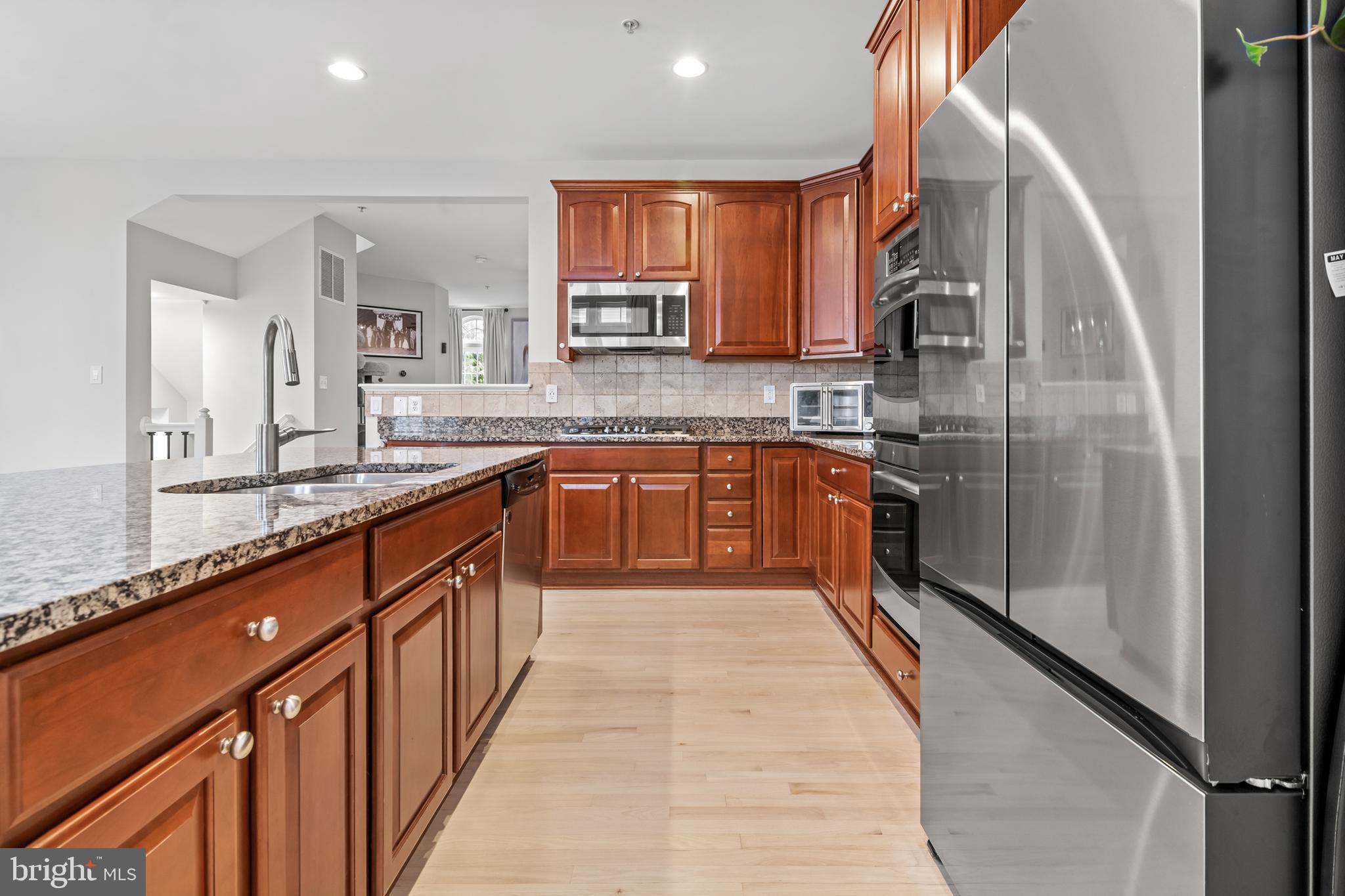1750 Theale Way Hanover, MD 21076 - Photo 14 of 42 a large kitchen with stainless steel appliances granite countertop a sink counter space cabinets and a large window