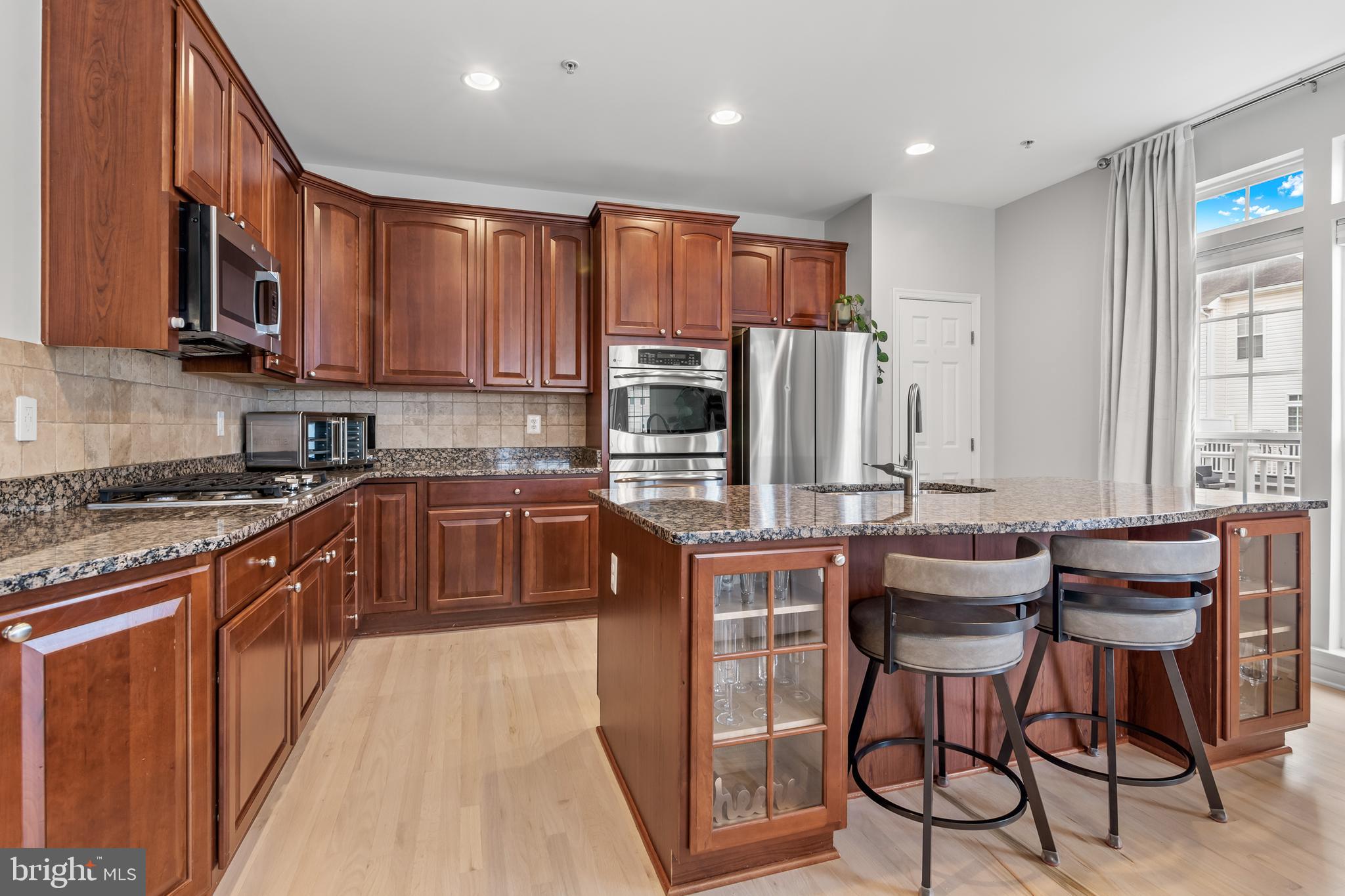 1750 Theale Way Hanover, MD 21076 - Photo 16 of 42 a kitchen with stainless steel appliances granite countertop wooden cabinets a stove top oven a sink and dishwasher