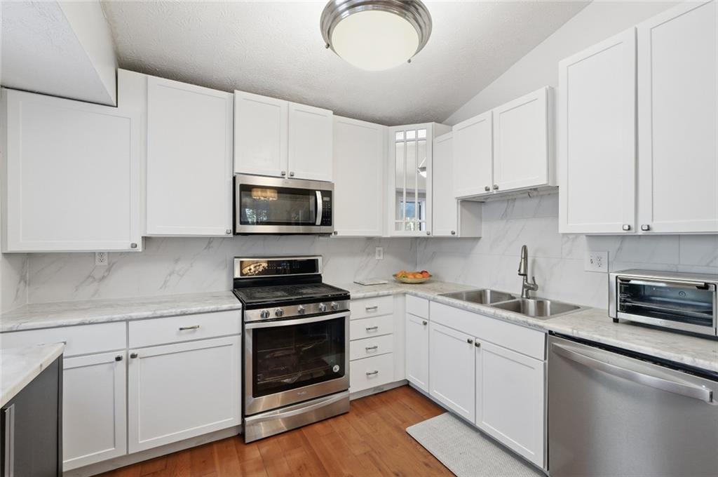 5421 Burdett Road Southeast Mableton, GA 30126 - Photo 18 of 51 a kitchen with cabinets stainless steel appliances and wooden floor