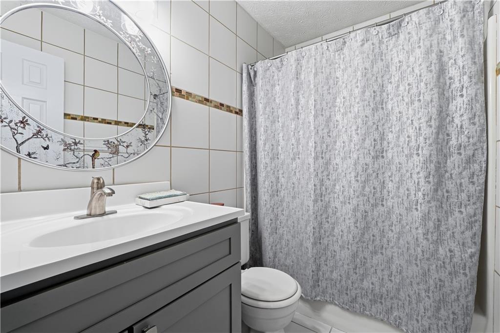 5421 Burdett Road Southeast Mableton, GA 30126 - Photo 30 of 51 a bathroom with a sink a toilet and shower curtain