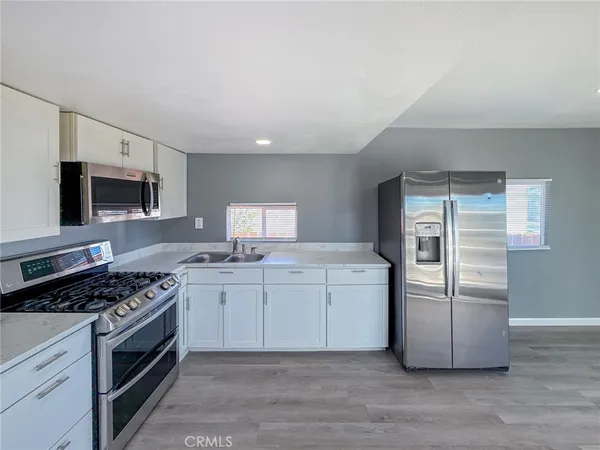 a kitchen with stainless steel appliances granite countertop a stove a sink and a refrigerator