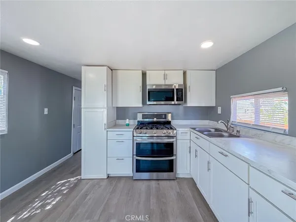 a kitchen with a stove a sink and a microwave