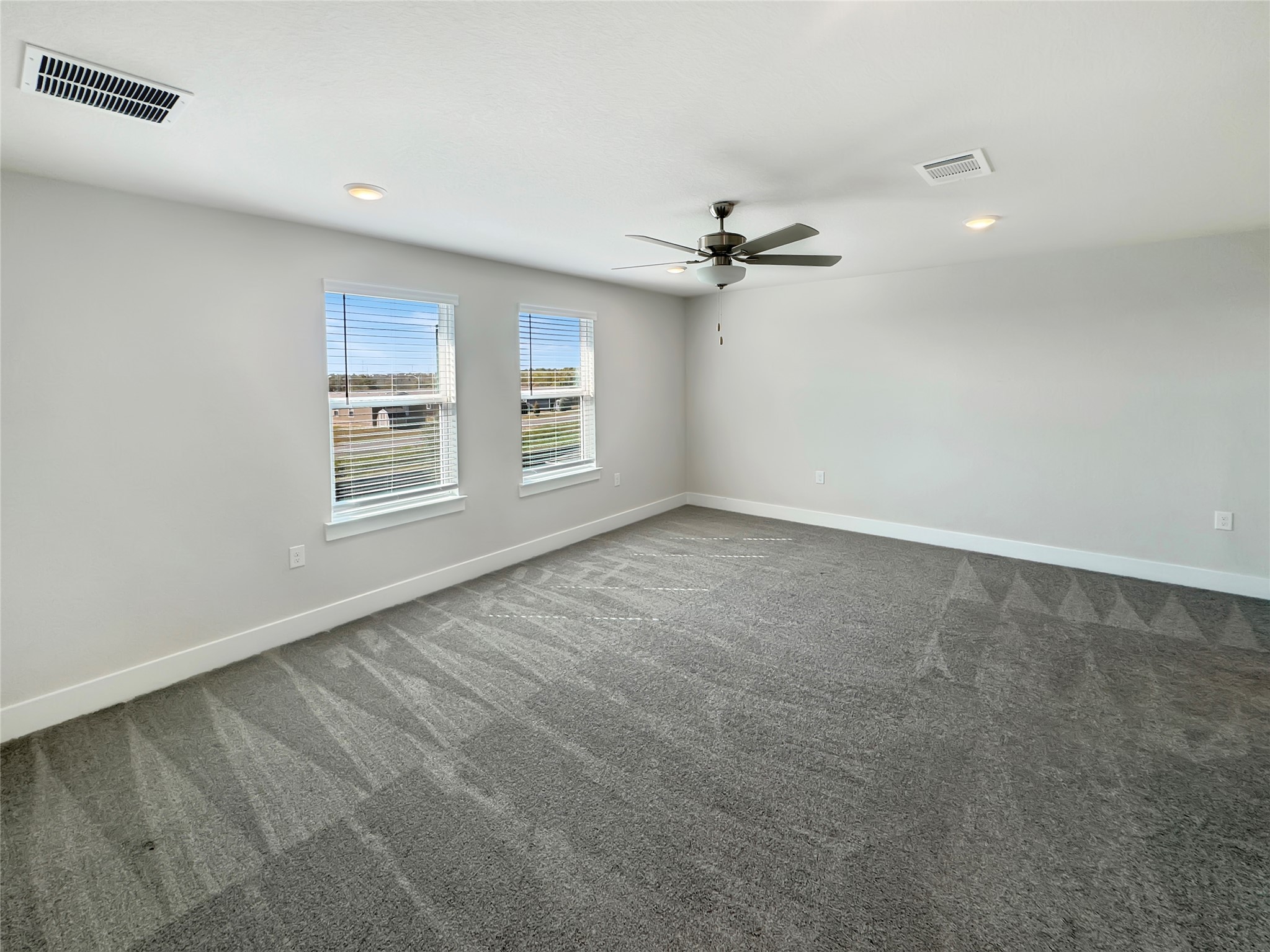 1704 Carvin Way Pflugerville, TX 78660 - Photo 20 of 30 Empty room featuring dark colored carpet, ceiling fan, and recessed lighting