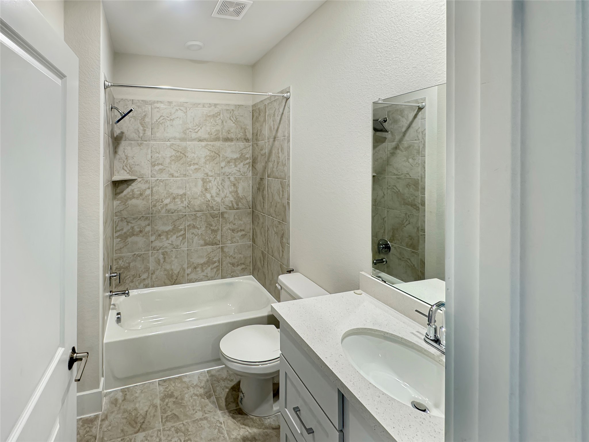 1704 Carvin Way Pflugerville, TX 78660 - Photo 6 of 30 Downstairs full bathroom featuring vanity, tub / shower combination, and a textured wall