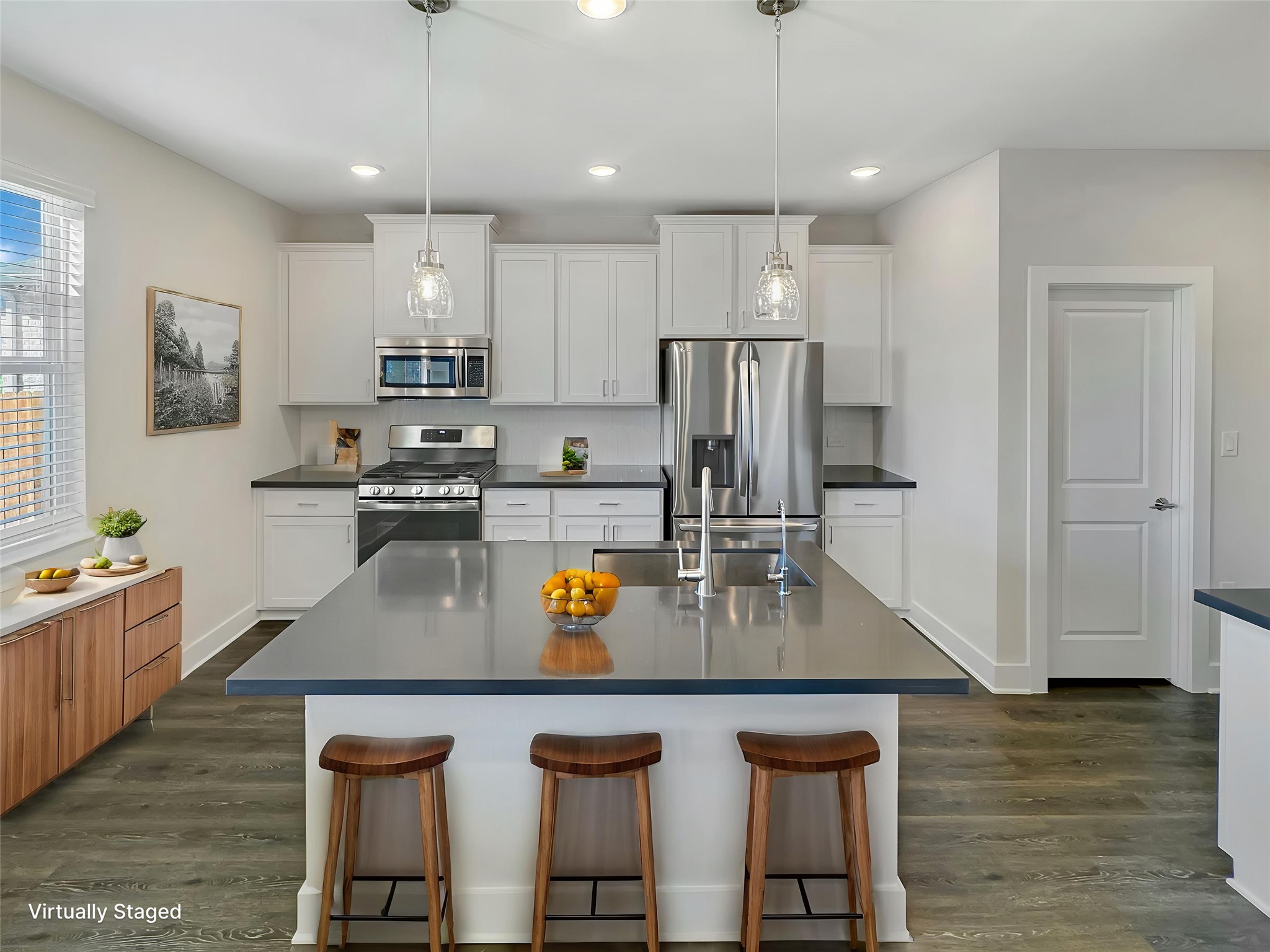 1704 Carvin Way Pflugerville, TX 78660 - Photo 8 of 30 Kitchen with a kitchen bar, white cabinetry, dark countertops, stainless steel appliances, and dark wood-style flooring
