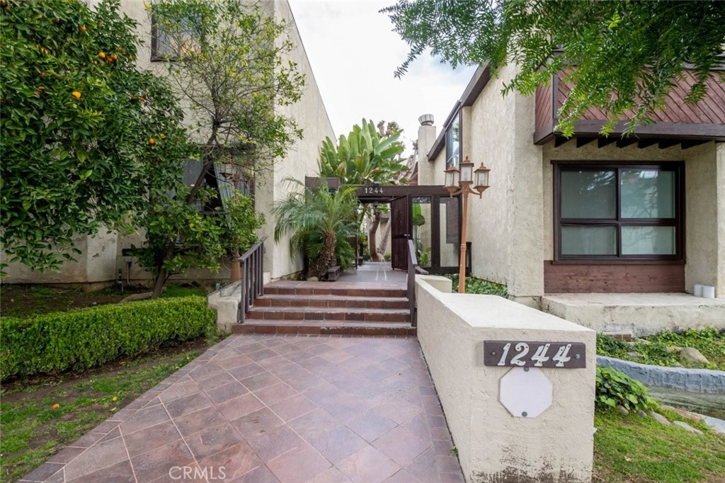 a front view of a house with garden and plants