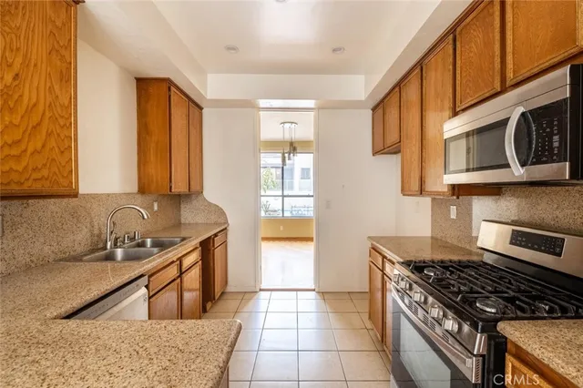 a kitchen with stainless steel appliances granite countertop a refrigerator and a sink