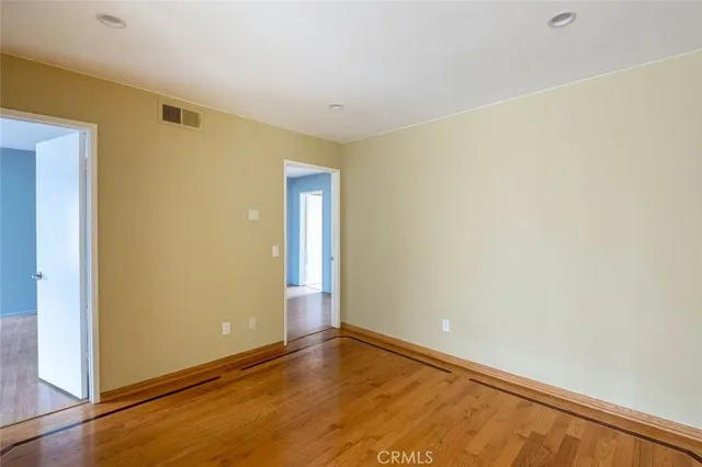 a view of a hallway with wooden floor and cabinet