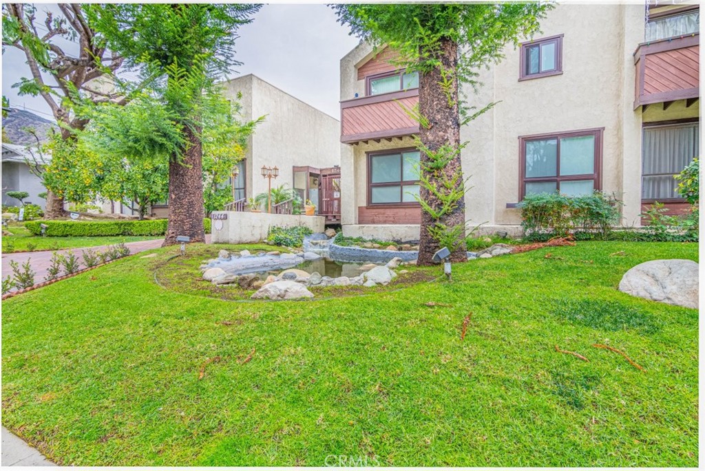 1244 Valley View Road, Unit 129 Glendale, CA 91202 - Photo 3 of 42 a view of a patio with table and chairs and potted plants and large trees