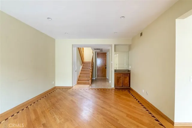 a view of empty room with fireplace and wooden floor