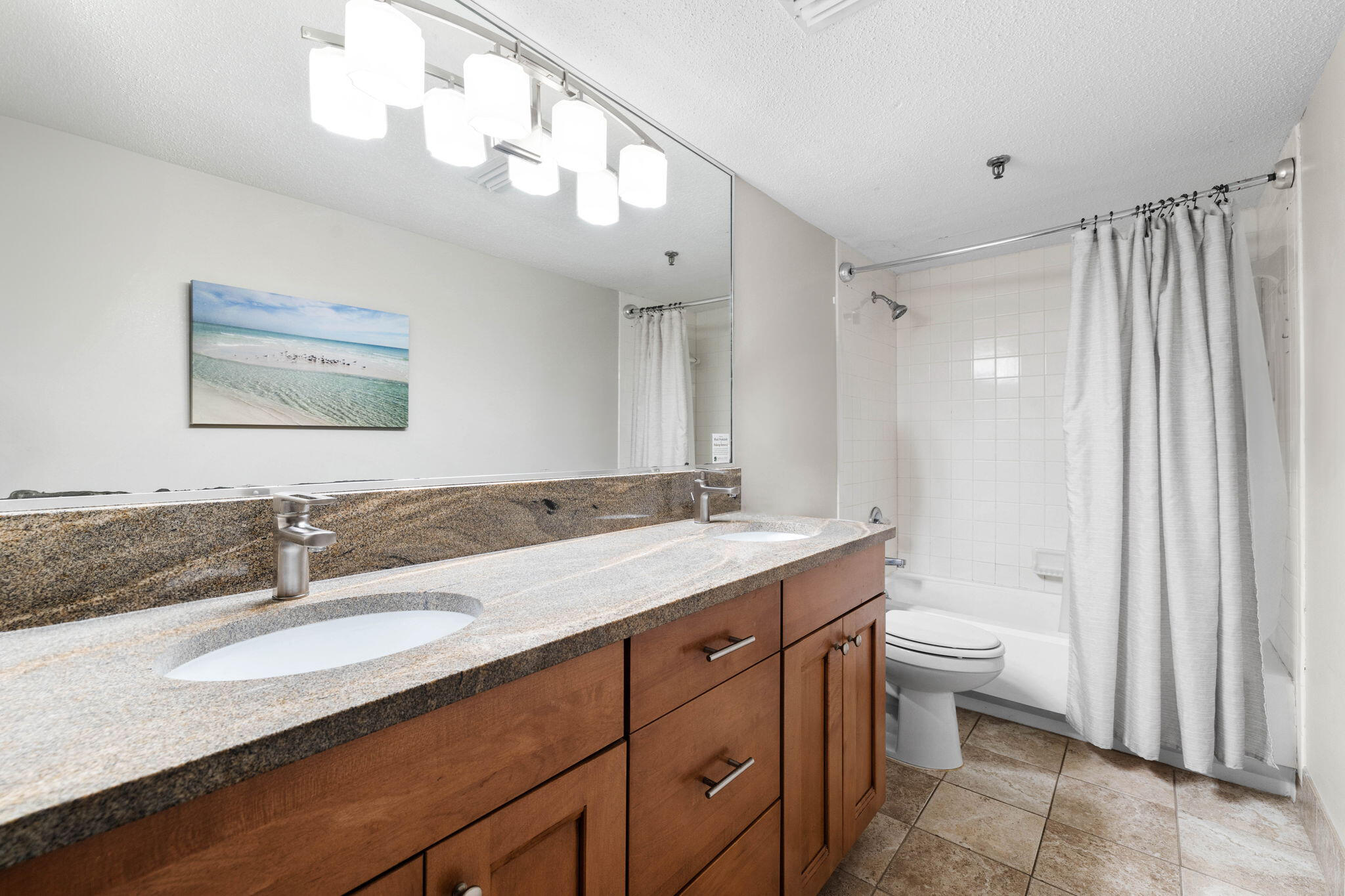 600 Gulf Shore Drive, Unit 304 Destin, FL 32541 - Photo 23 of 38 a bathroom with a granite countertop sink a toilet and a mirror