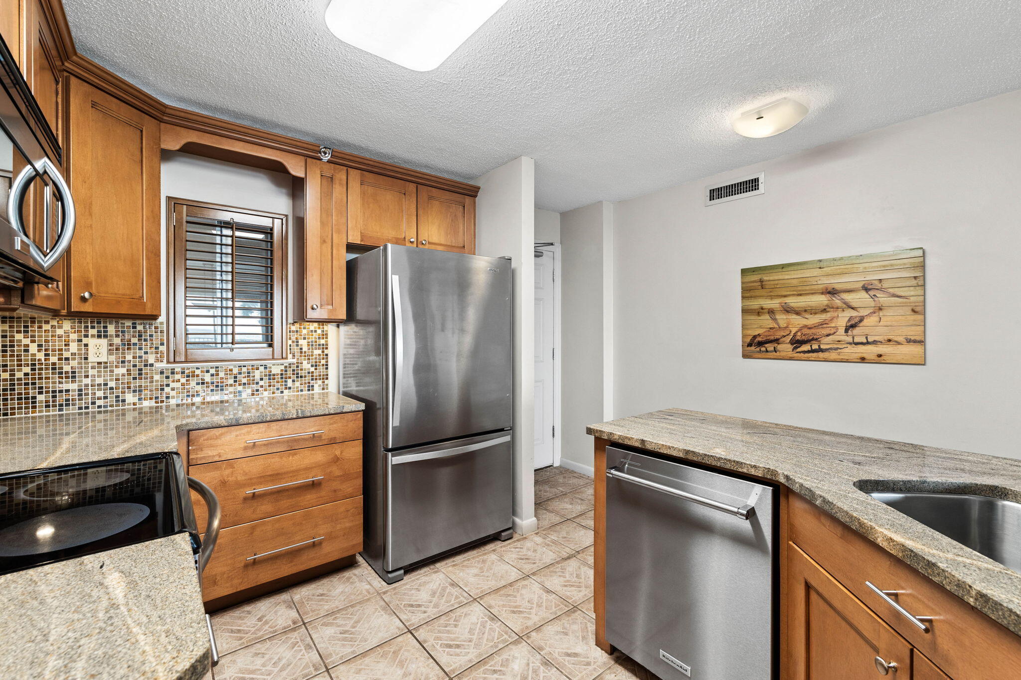 600 Gulf Shore Drive, Unit 304 Destin, FL 32541 - Photo 4 of 38 a kitchen with granite countertop a refrigerator and a stove top oven