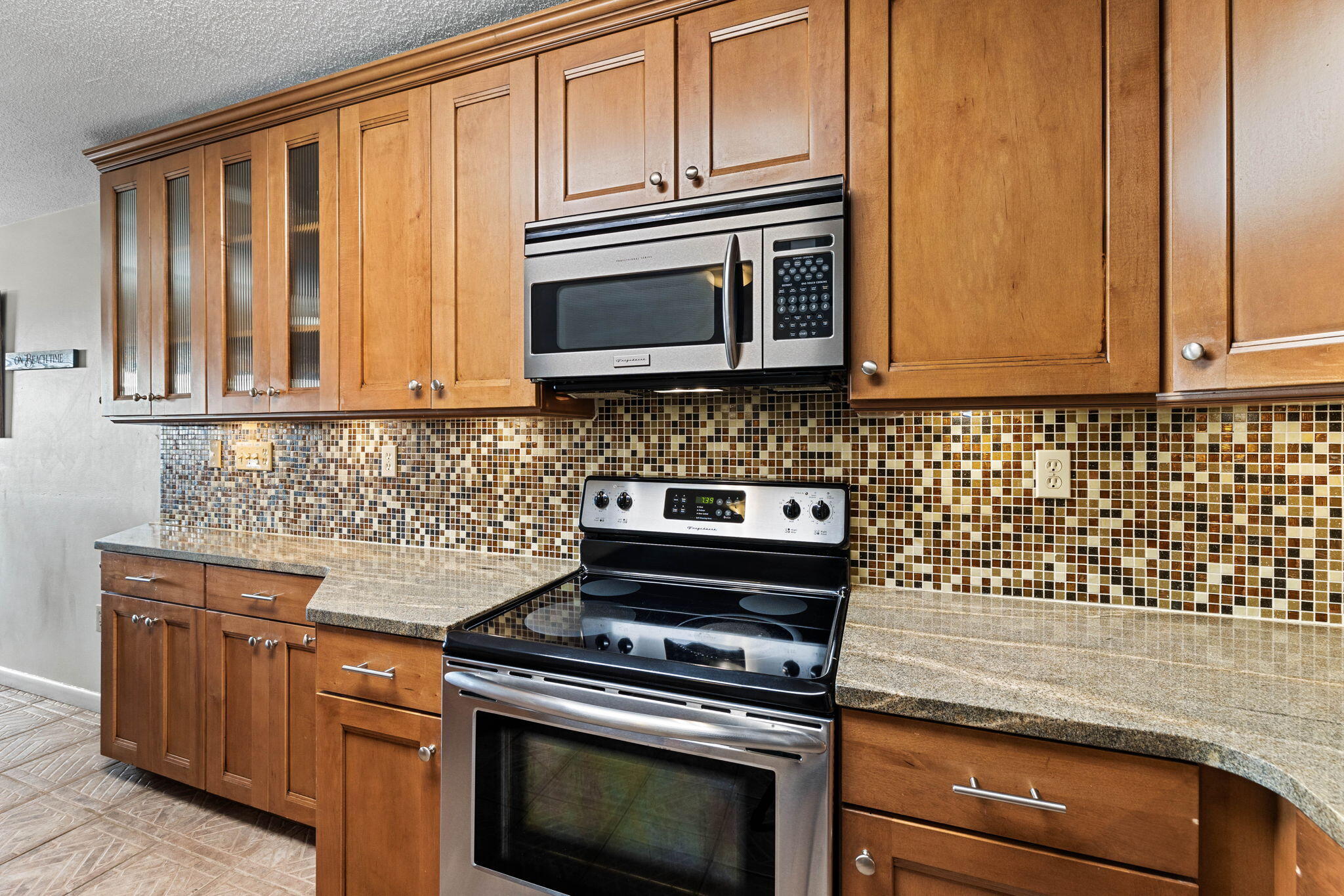 600 Gulf Shore Drive, Unit 304 Destin, FL 32541 - Photo 5 of 38 a kitchen with granite countertop cabinets stove top oven and microwave