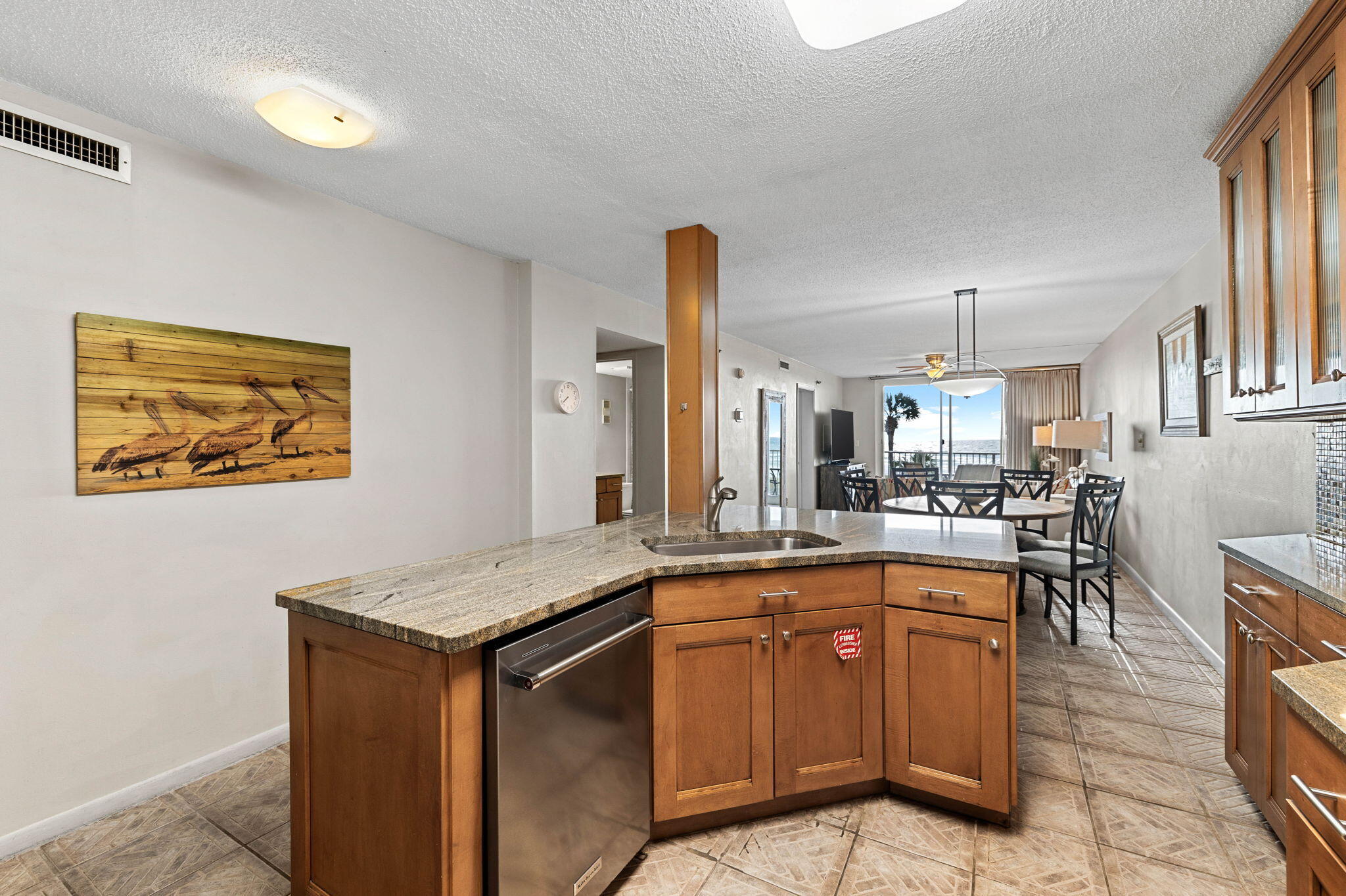 600 Gulf Shore Drive, Unit 304 Destin, FL 32541 - Photo 6 of 38 a view of a kitchen with kitchen island a sink a counter space and a view of living room