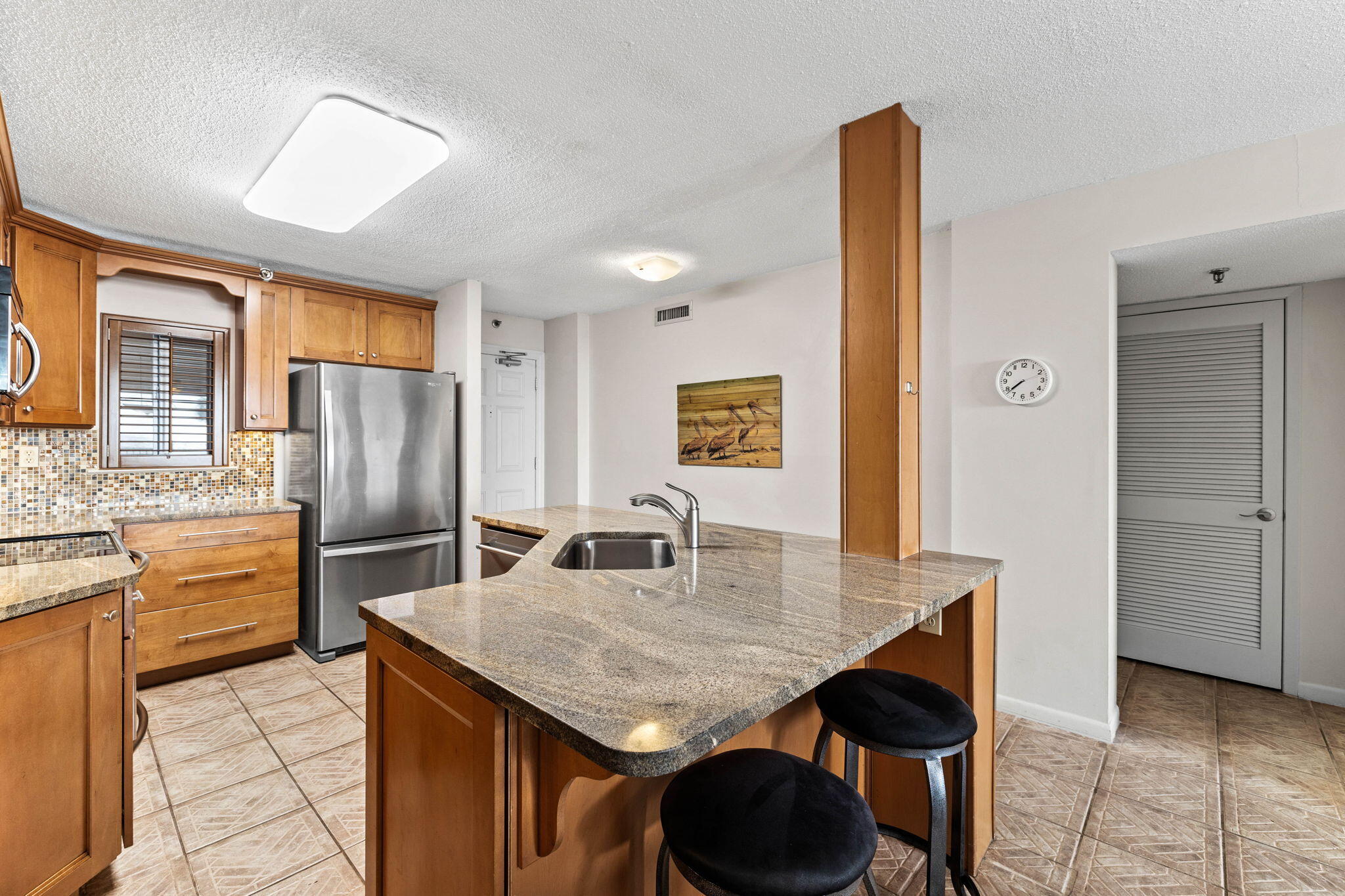 600 Gulf Shore Drive, Unit 304 Destin, FL 32541 - Photo 8 of 38 a kitchen with stainless steel appliances granite countertop a kitchen island a stove a refrigerator a sink a dining table and chairs with wooden floor
