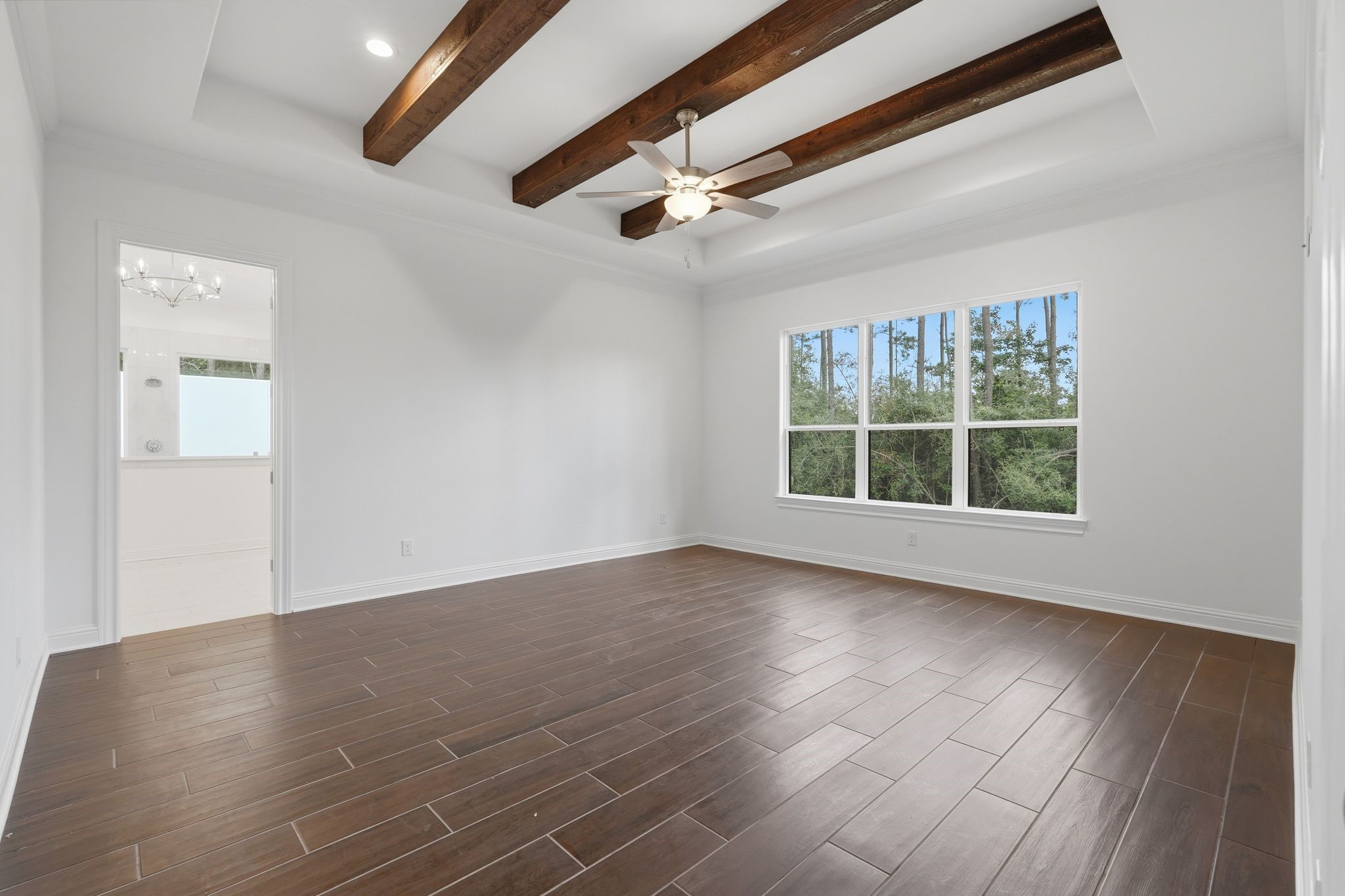 16081 Forest Mill Road Willis, TX 77378 - Photo 17 of 37 Designed for relaxation and comfort, this spacious primary retreat features soaring wood-beamed ceilings, beautiful natural light, and a tranquil atmosphere you’ll love coming home to.