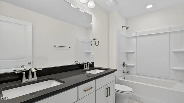 a bathroom with a granite countertop sink a toilet a mirror and shower