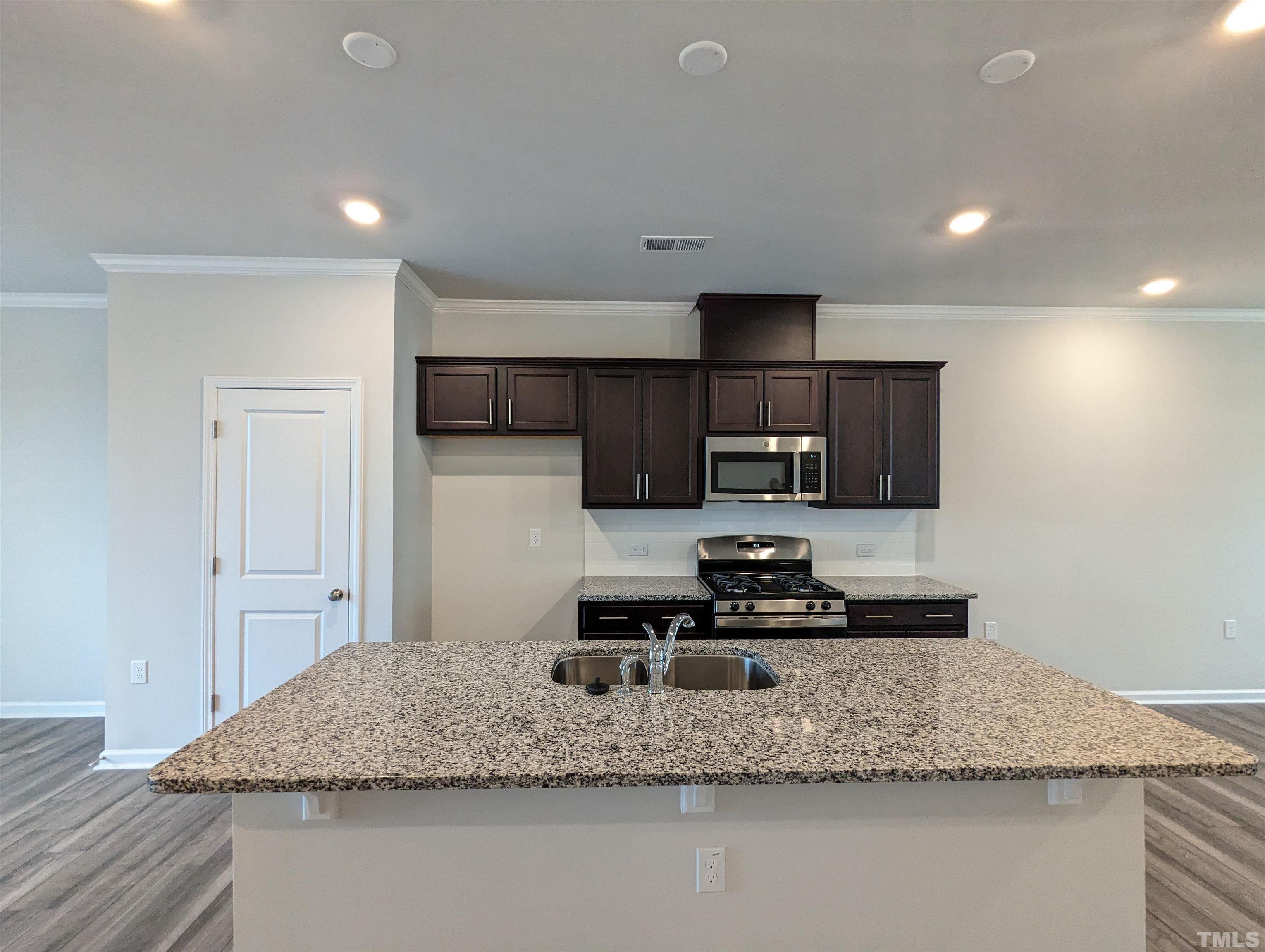 604 Gimari Drive Wake Forest, NC 27587 - Photo 2 of 20 a kitchen with kitchen island granite countertop a sink a stove and a refrigerator