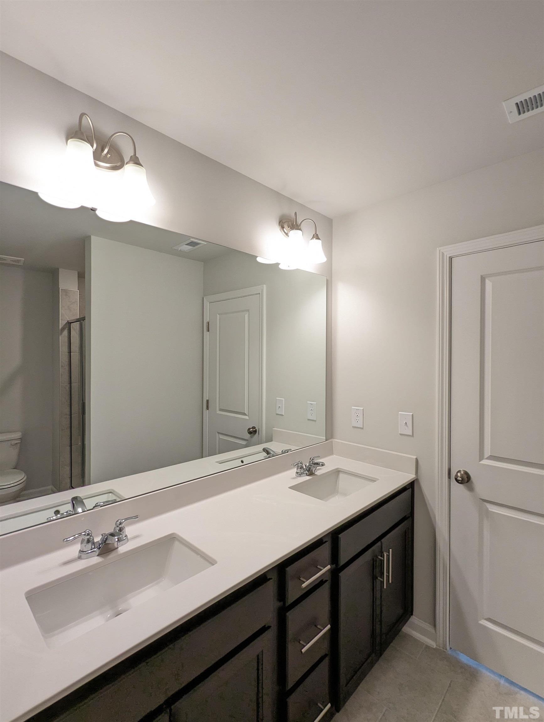 604 Gimari Drive Wake Forest, NC 27587 - Photo 9 of 20 a bathroom with a double vanity sink and a mirror
