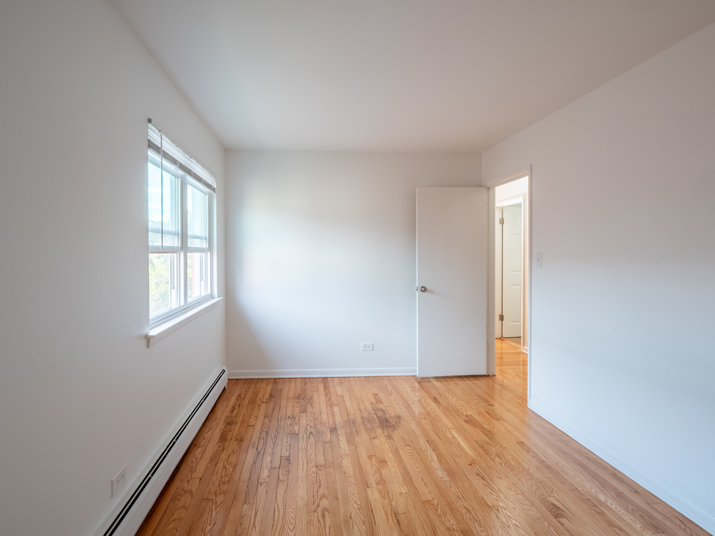 9662 Golf Terrace, Unit 2E Des Plaines, IL 60016 - Photo 13 of 24 an empty room with wooden floor and windows