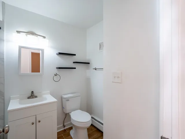 a bathroom with a toilet sink and mirror