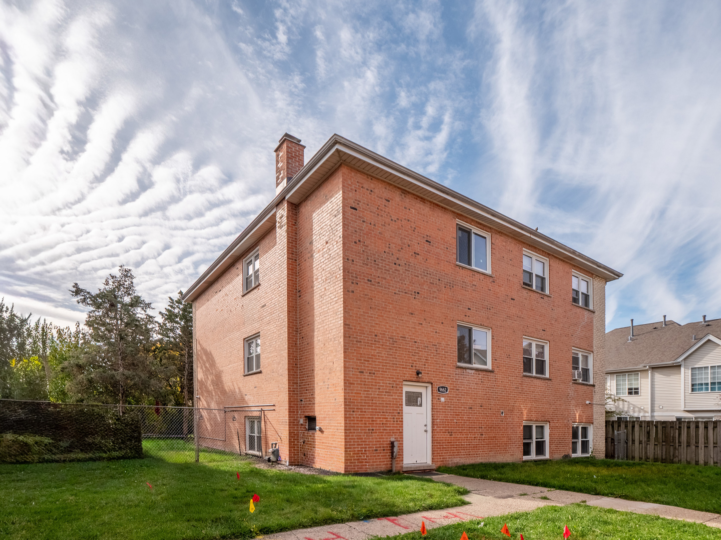 9662 Golf Terrace, Unit 2E Des Plaines, IL 60016 - Photo 2 of 24 a backyard of a house with plants and large tree