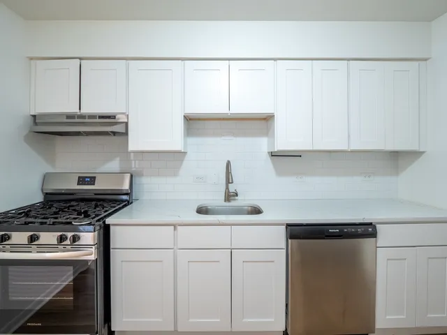 a kitchen with stainless steel appliances granite countertop a sink a stove and cabinets