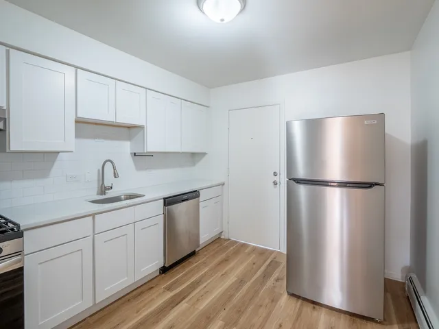 a kitchen with stainless steel appliances a refrigerator sink and cabinets