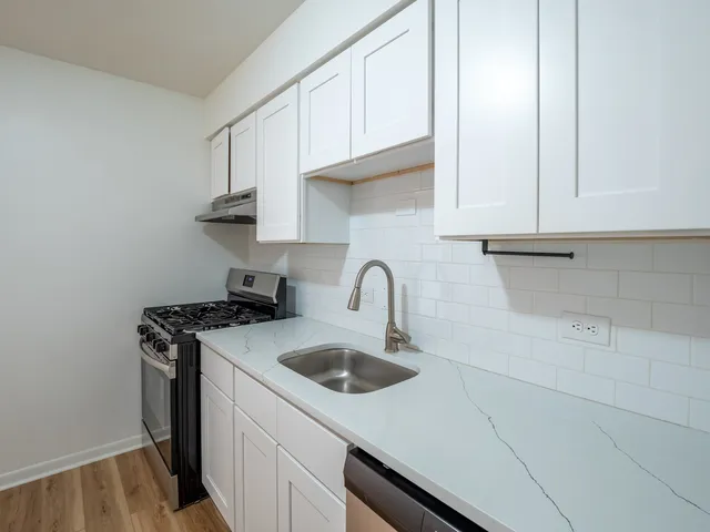 a kitchen with stainless steel appliances granite countertop a sink a stove and cabinets