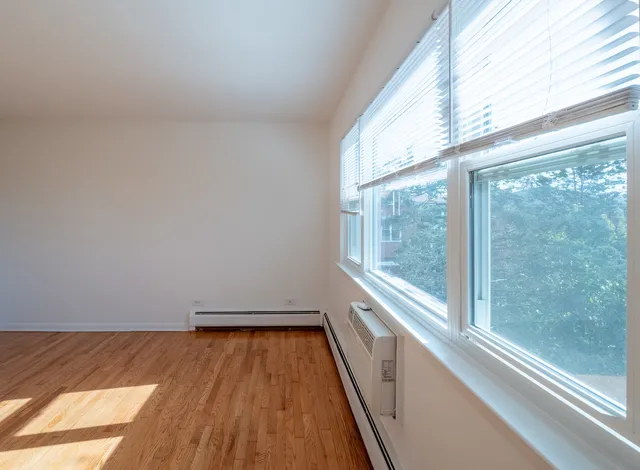 a view of a room with wooden floor and a window