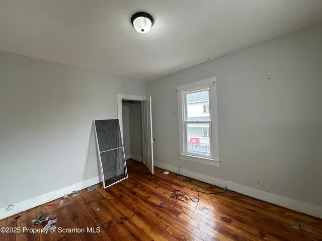 an empty room with closet and windows