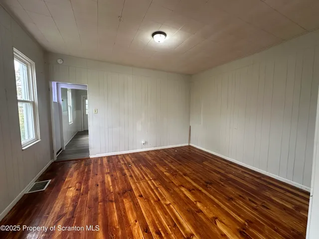a view of empty room with wooden floor