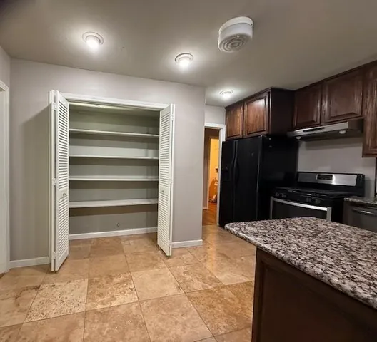 a kitchen with a refrigerator and a stove top oven