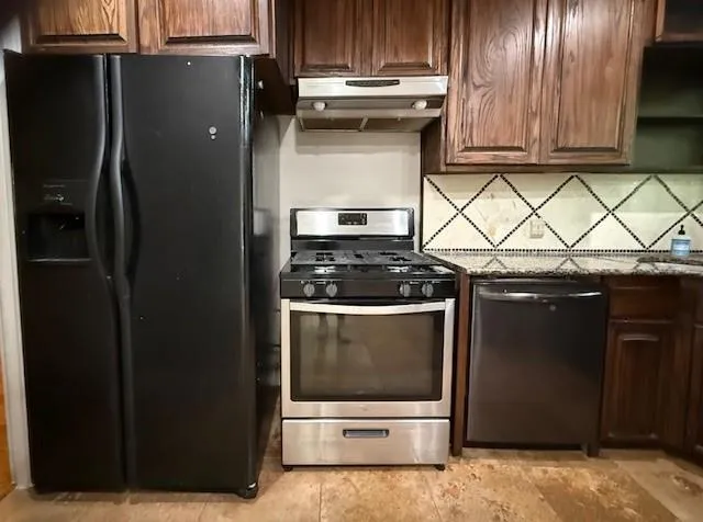 a kitchen with granite countertop a refrigerator and a stove