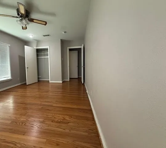a view of a hallway with wooden floor and staircase