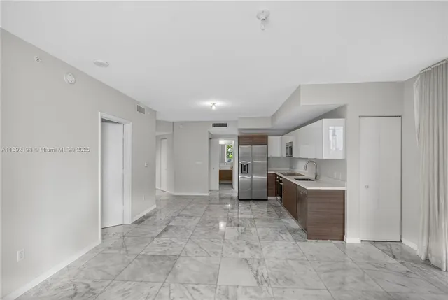 a kitchen with stainless steel appliances a refrigerator and more cabinets