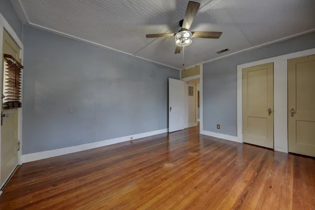 a view of an empty room with wooden floor