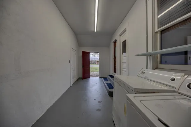 a view of a hallway with entryway and wooden floor