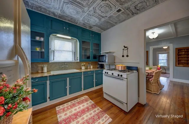 a kitchen with kitchen island a stove a counter space a sink and cabinets