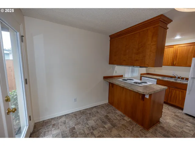 a kitchen with stainless steel appliances granite countertop a refrigerator and a stove